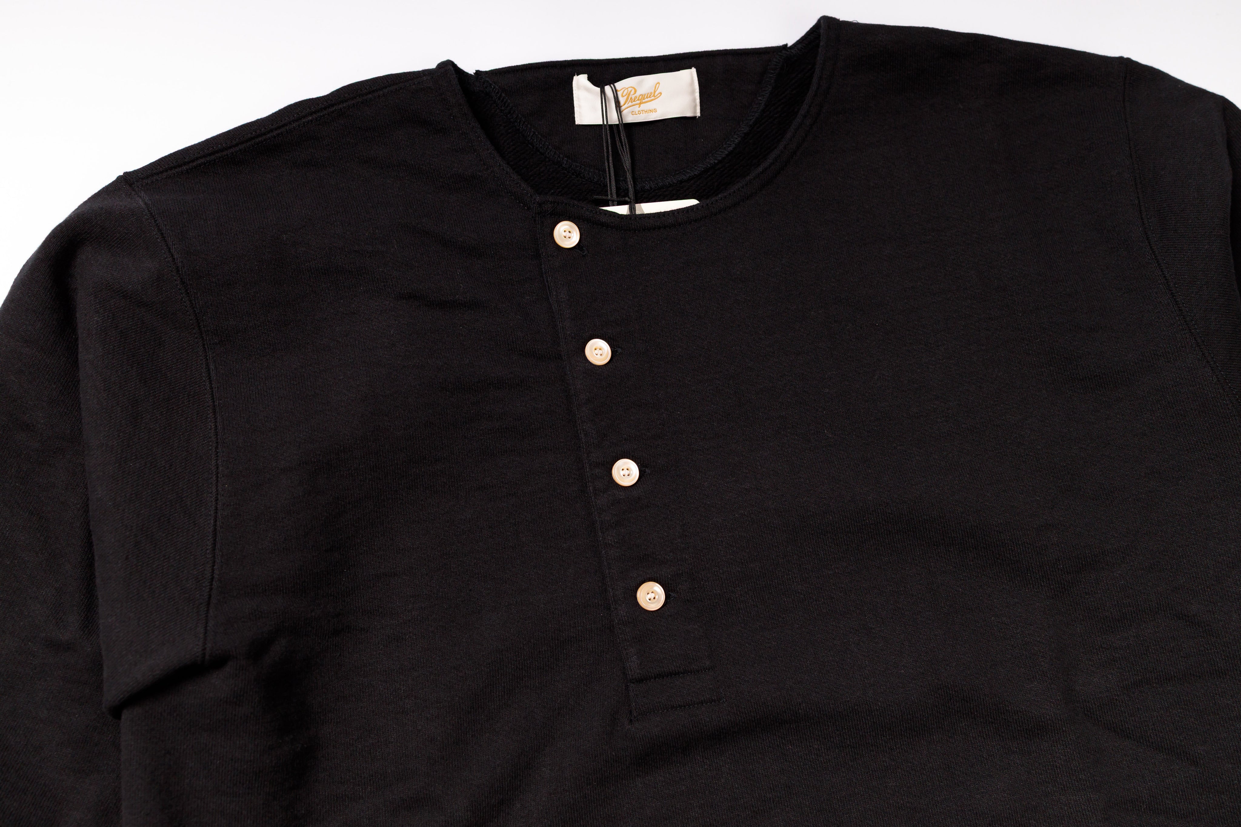 Black henley shirt with buttons on a white background