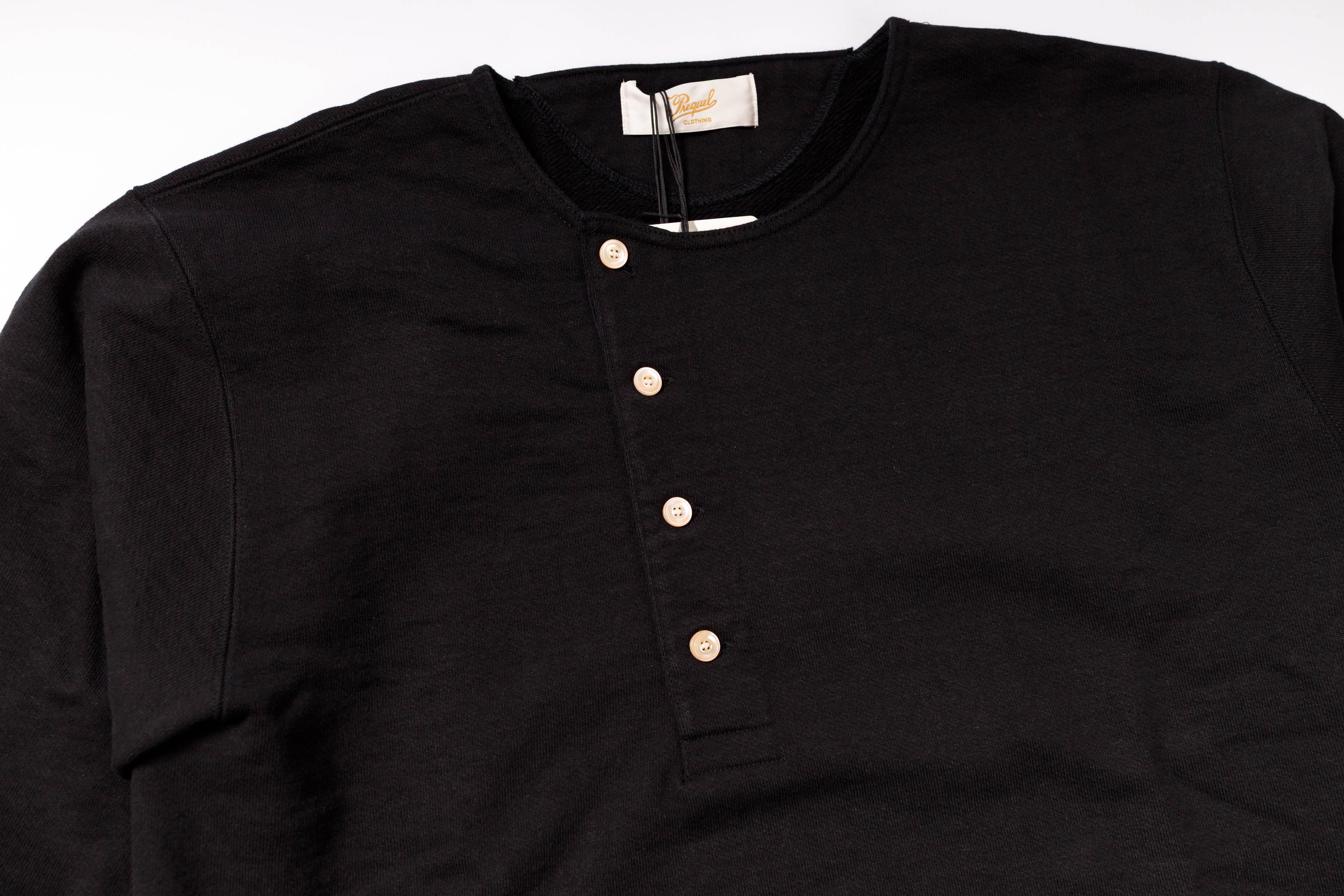 Black henley shirt with buttons on a white background