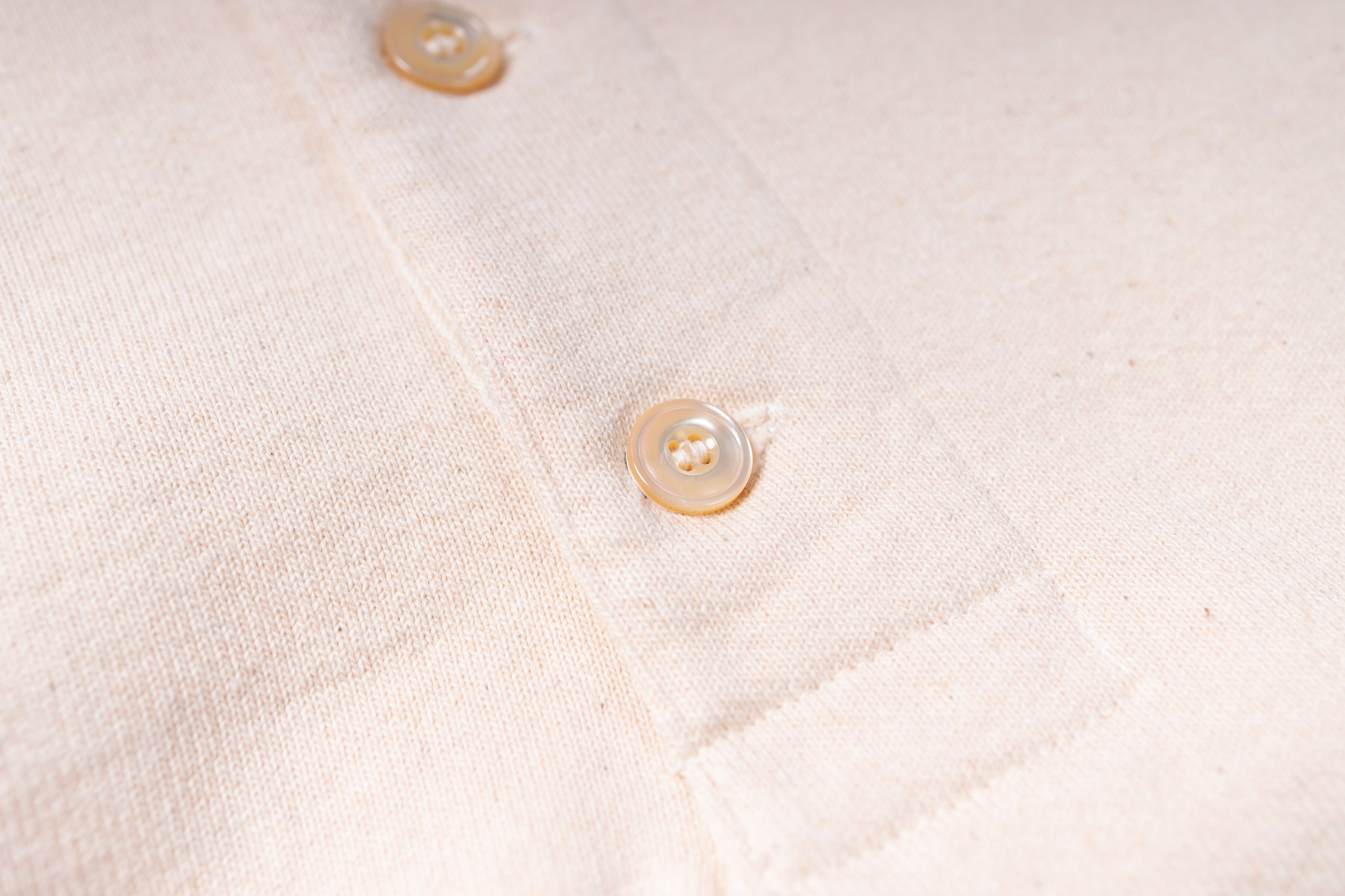 Close-up of a textured beige fabric with buttons