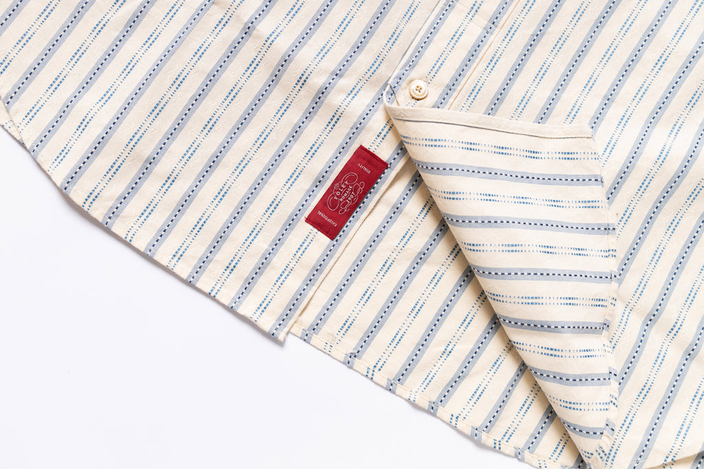 Folded fabric with blue stripes and a red label on a white background