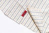 Folded fabric with blue stripes and a red label on a white background