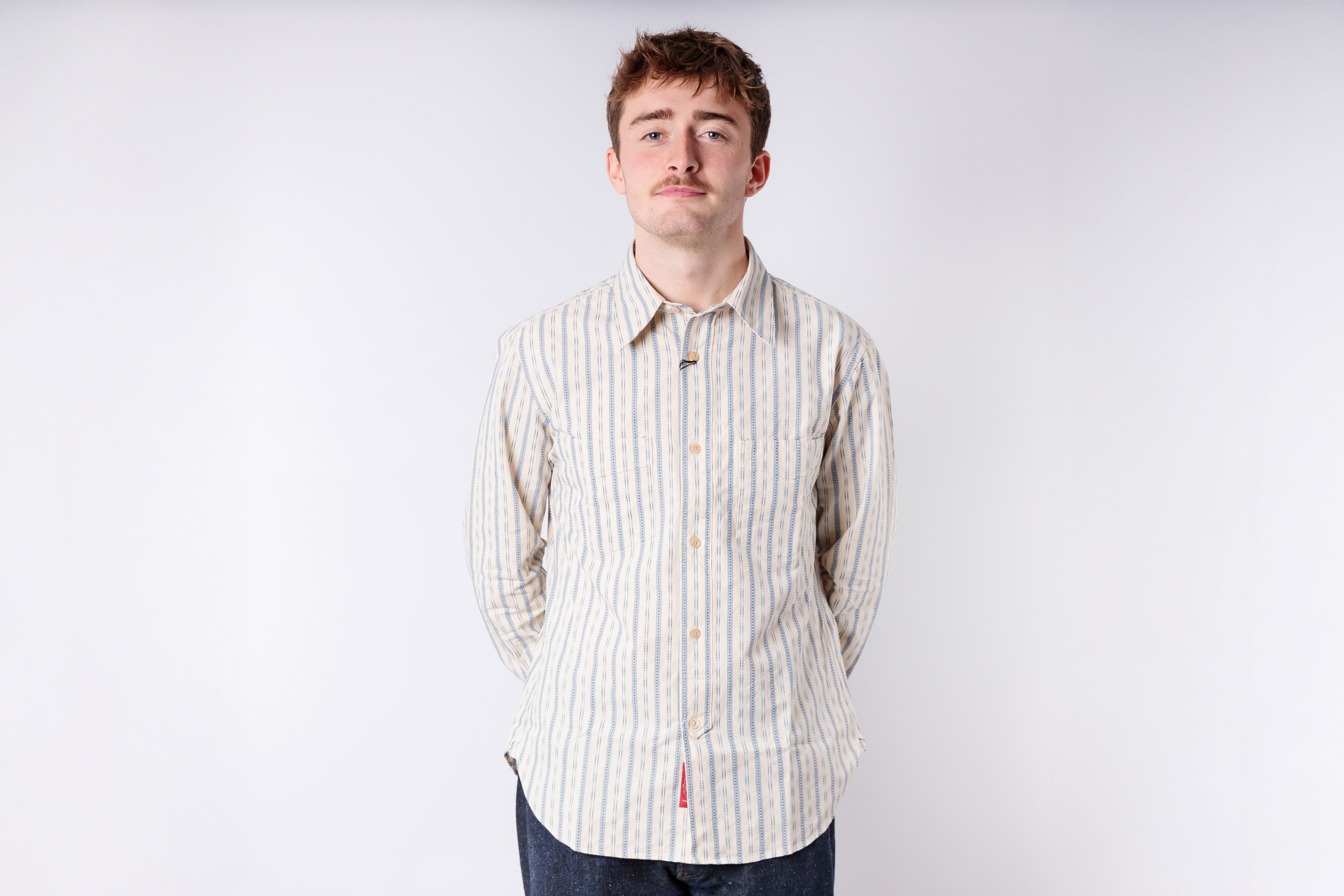 Man wearing a striped shirt against a plain background
