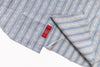 Folded blue and white striped fabric with a red tag on a white background