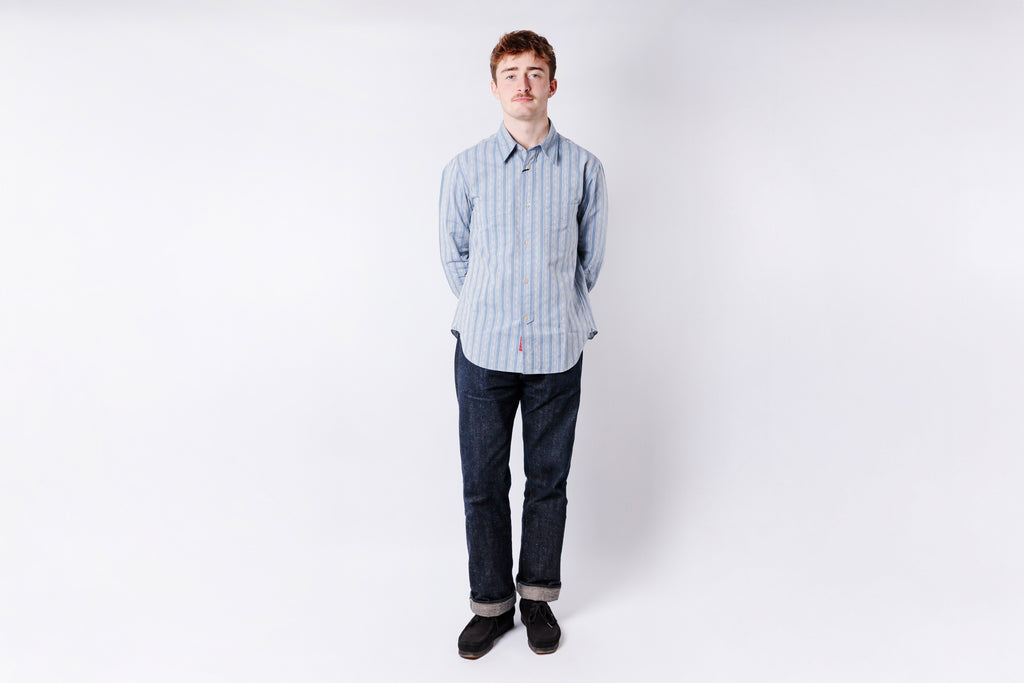 Person wearing a striped shirt and jeans on a white background