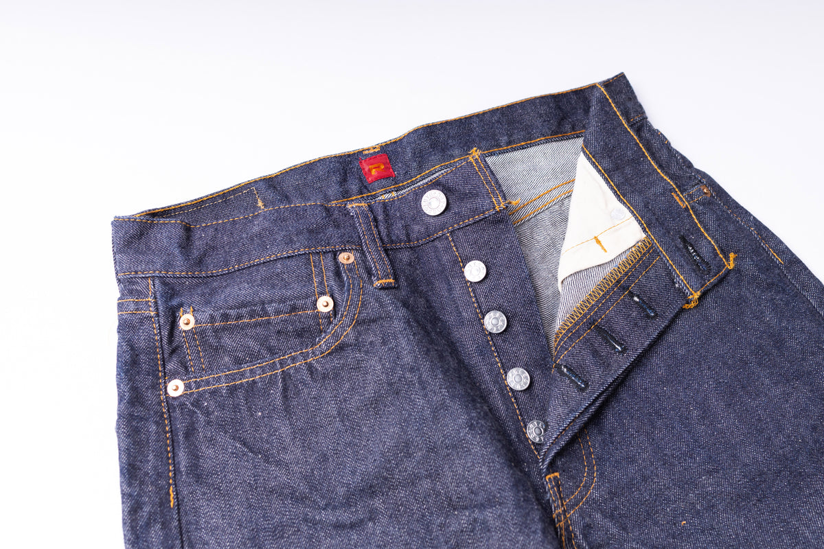 Close-up of a blue denim jacket with buttons on a white background