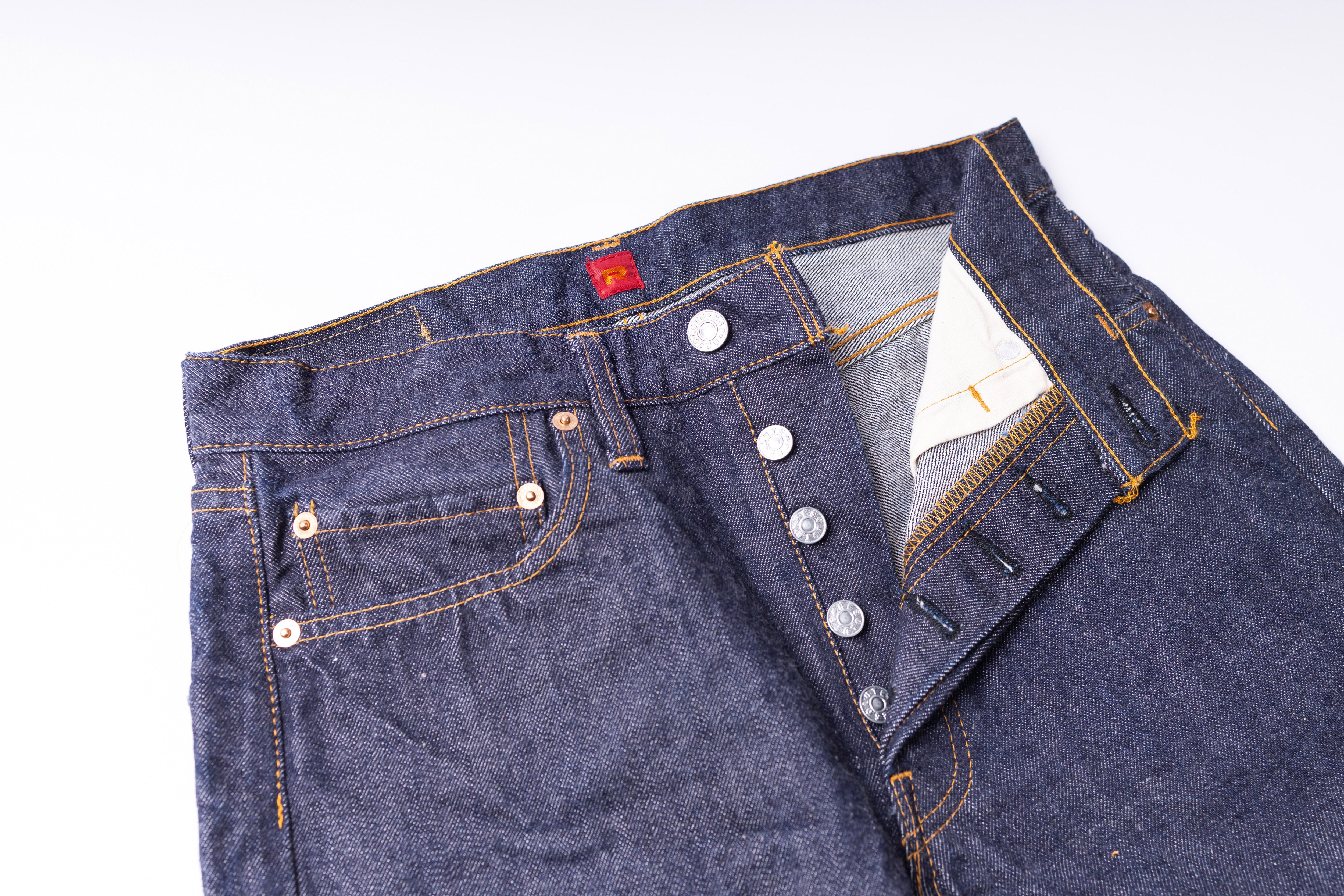 Close-up of a blue denim jacket with buttons on a white background