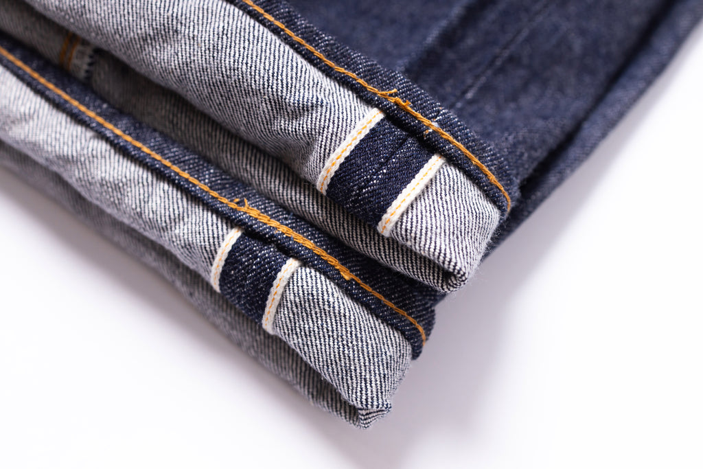 Close-up of folded denim jeans on a white background