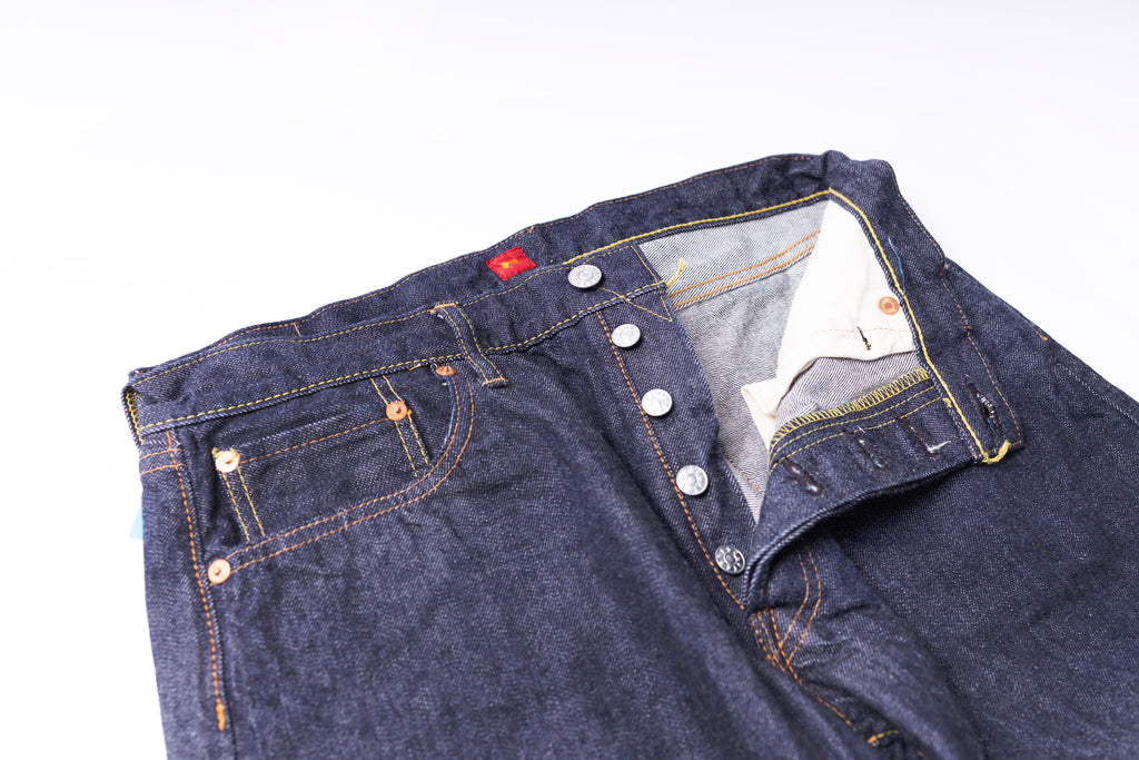 Close-up of a folded pair of blue jeans with a white background