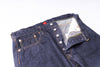 Close-up of a folded pair of blue jeans with a white background