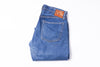 Folded blue jeans with  label on a white background