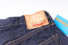 Close-up of a denim jeans label with 'Resolute' branding on a white background
