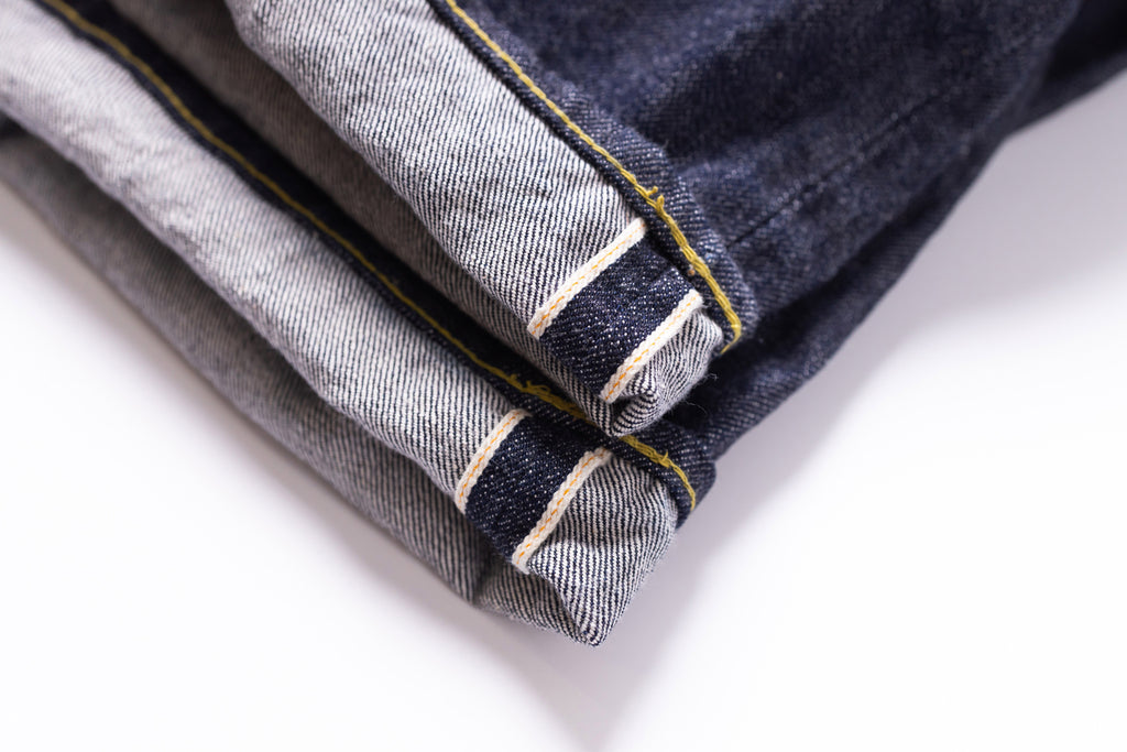 Stack of folded denim jeans on a white background