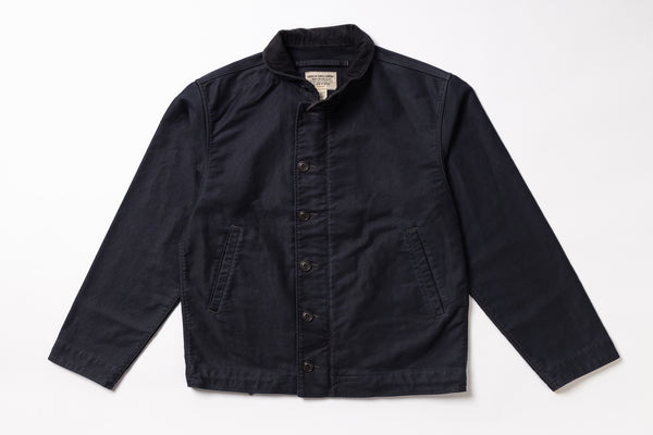 A dark navy blue canvas utility jacket with a button-up front, laid flat against a white background.