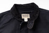 Close-up of a dark navy overshirt collar with a ribbed corduroy-like texture and a sewn-in label reading Double RL. Supply Company.