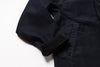 Close-up of a dark navy blue jacket or overshirt showing the sleeve cuff, buttoned collar, and a side pocket on a white background.