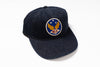 A dark navy blue denim baseball cap featuring a circular embroidered patch on the front with a gold winged emblem, blue background, white stars, and the letters 'RRL' in red.