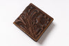A brown tooled leather bifold wallet with floral and leaf embossed patterns and contrast stitching, shown on a plain white background.