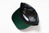 A green and black trucker cap with a dark green visor and black mesh back panels, shown from an overhead angle on a white background.