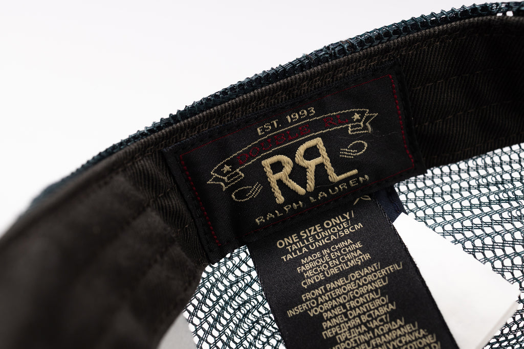 Close-up of a black mesh and fabric interior label of a Ralph Lauren cap, showing the brand name 'Ralph Lauren' and size information in gold and white text.