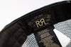 Close-up of a black mesh and fabric interior label of a Ralph Lauren cap, showing the brand name 'Ralph Lauren' and size information in gold and white text.