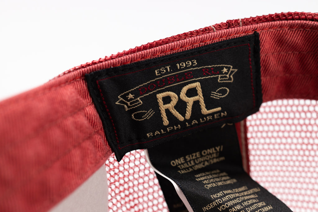 Close-up of the interior label of a red cap, showing a black Ralph Lauren patch with gold embroidery reading 'Est. 1993 Double RL' and 'Ralph Lauren', alongside a white mesh fabric and inner tag.