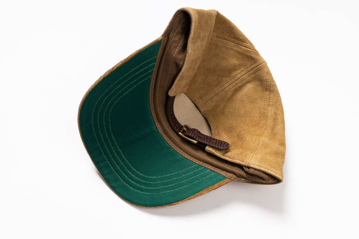 A vintage-style baseball cap with a tan suede-like crown and a dark green visor, shown from an overhead angle on a white background.