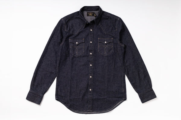 A dark indigo denim western-style shirt jacket with long sleeves, button-down front, and two chest pockets, laid flat on a white background.
