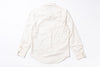 An off-white long-sleeve cotton  shirt shown from the back, laid flat on a white background. The shirt features a natural linen texture, a curved hem, and button details on the cuffs.