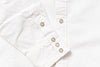 Close-up of a white button-up shirt sleeve with snap-button cuff and a vertical button placket.