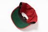 A red and green baseball cap shown from an overhead angle on a white background, displaying the red crown, green visor underside, black inner lining, and gold-tone buckle.