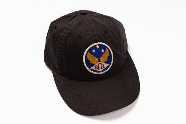 A black cotton baseball cap featuring a circular embroidered patch on the front with a blue background, gold wings, white stars, and the letters 'RPL' in red.