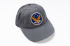 A gray cotton baseball cap featuring an embroidered circular patch on the front with a blue background, white stars, gold wings, and the letters 'RRL' in red, photographed on a clean white background.