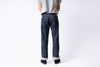 Person wearing blue jeans and a gray shirt on a white background
