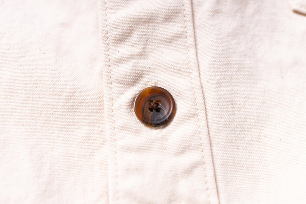 Close-up of a button on a light-colored fabric