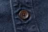 Close-up of a button on a blue textured fabric