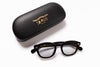 Black eyeglasses with gold text on a white background, accompanied by a matching black case.