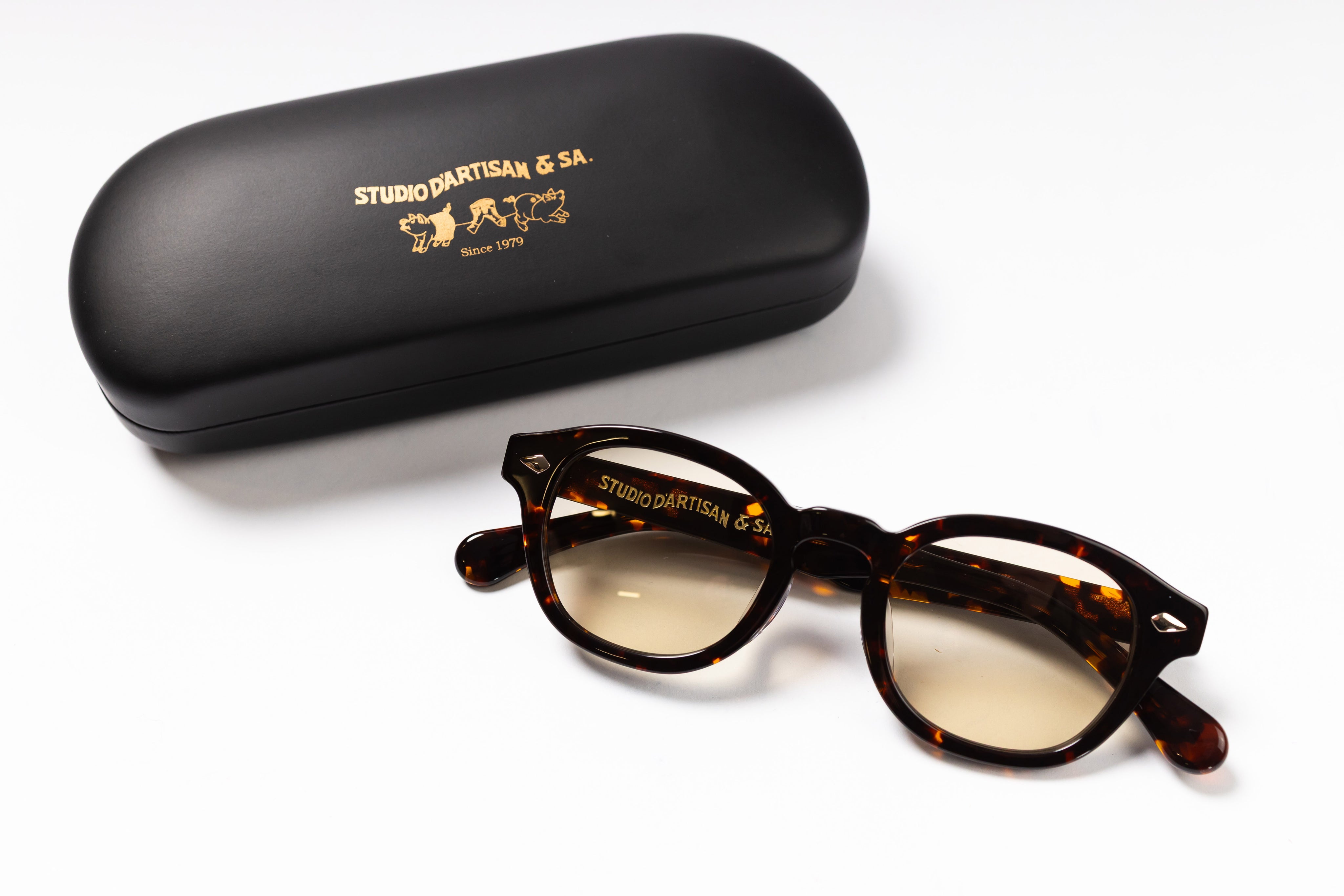 Tortoiseshell glasses with a black case on a white background.