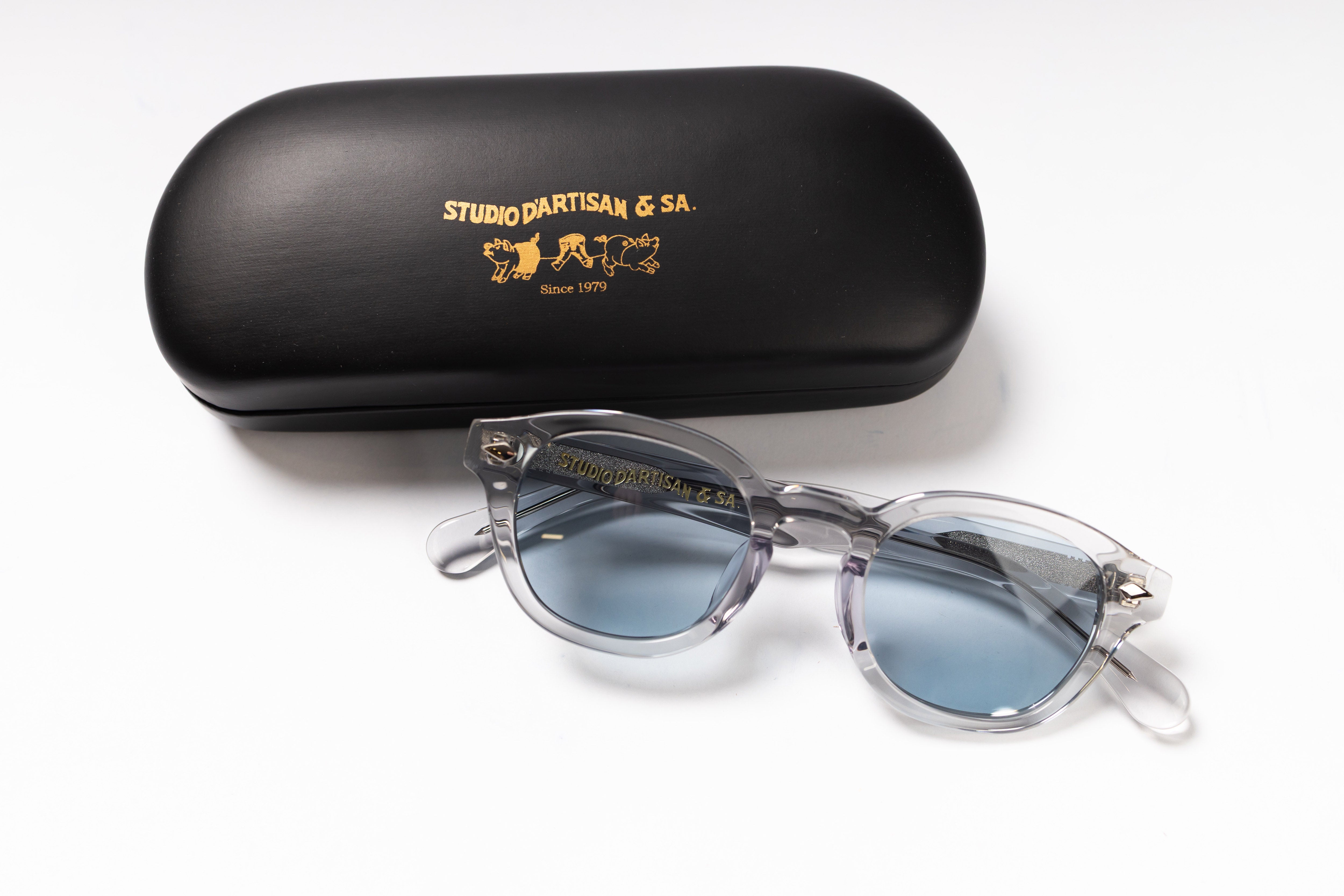 Sunglasses with blue lenses and a black case on a white background