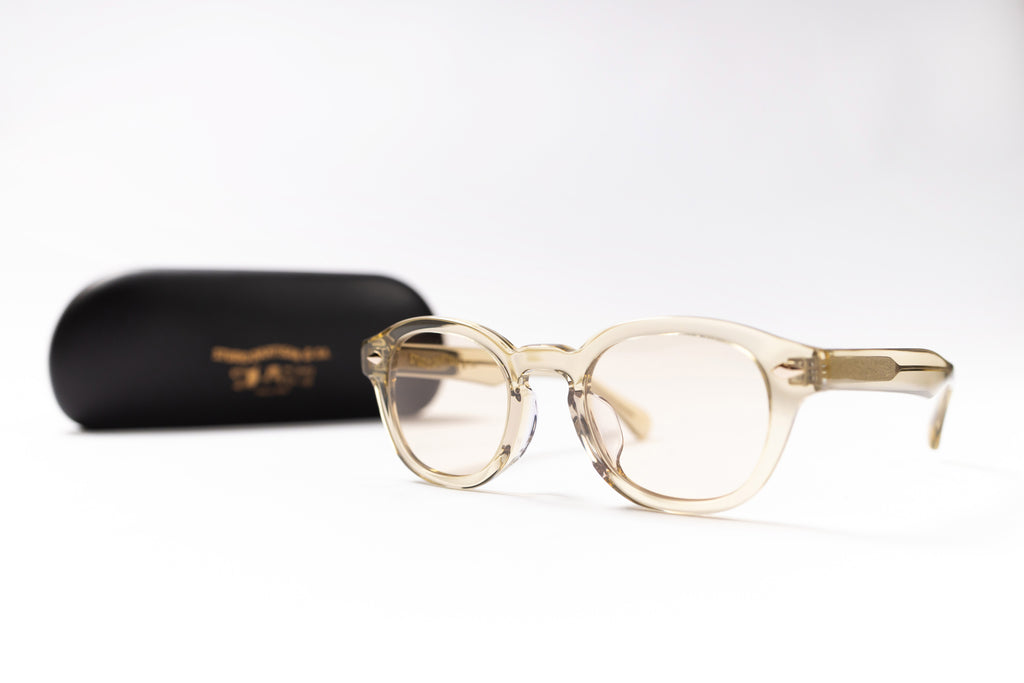 Beige eyeglasses with a black case on a white background
