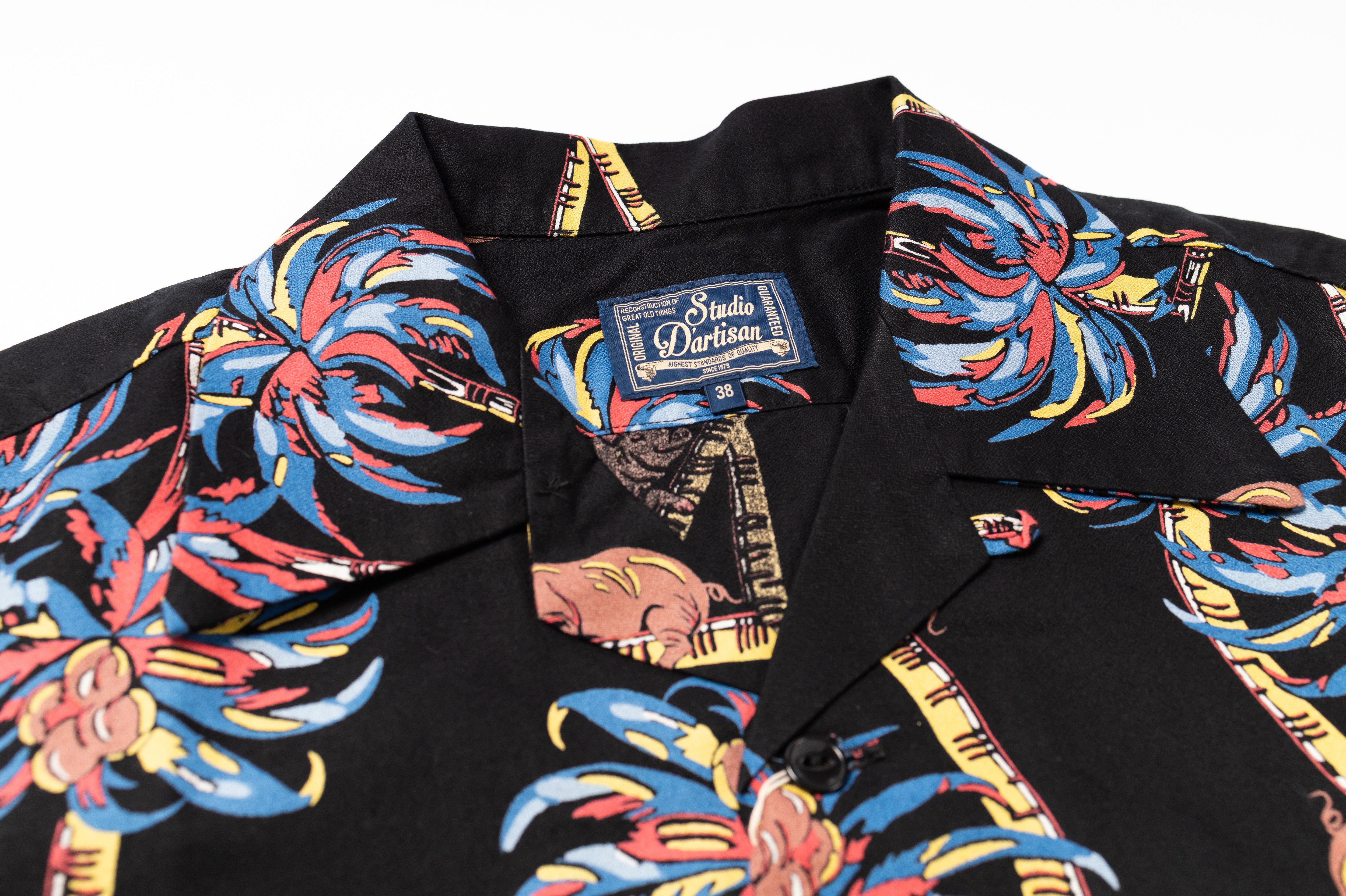 Black shirt with colorful palm tree design and Studio Doritos label.
