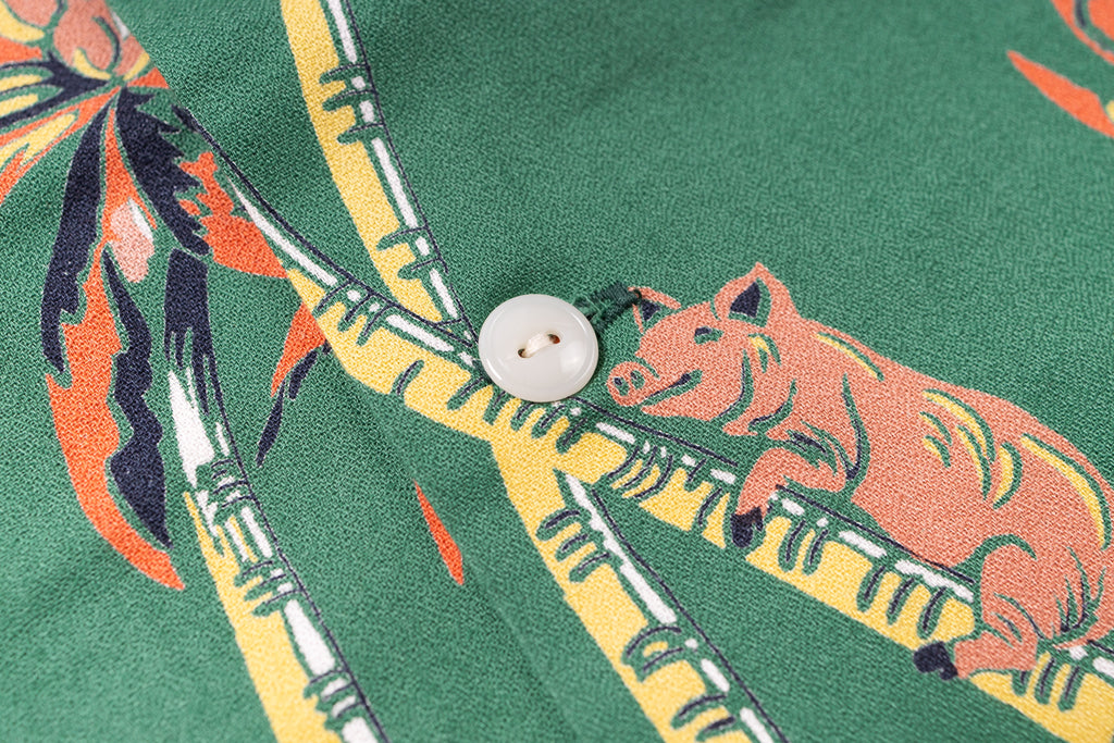Close-up of a shirt with pig and bamboo design on a green background