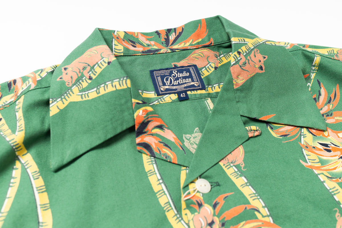 Green shirt with colorful pattern and 'Studio D'artisan' label on a white background