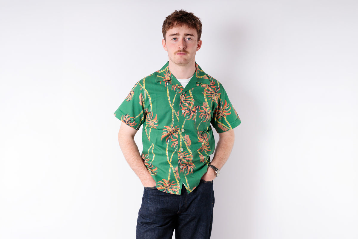 Man wearing a green floral shirt against a white background