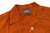 Close-up of a rust-orange suede or nubuck button-up shirt collar with a visible 'Studio D'Artisan' brand label.