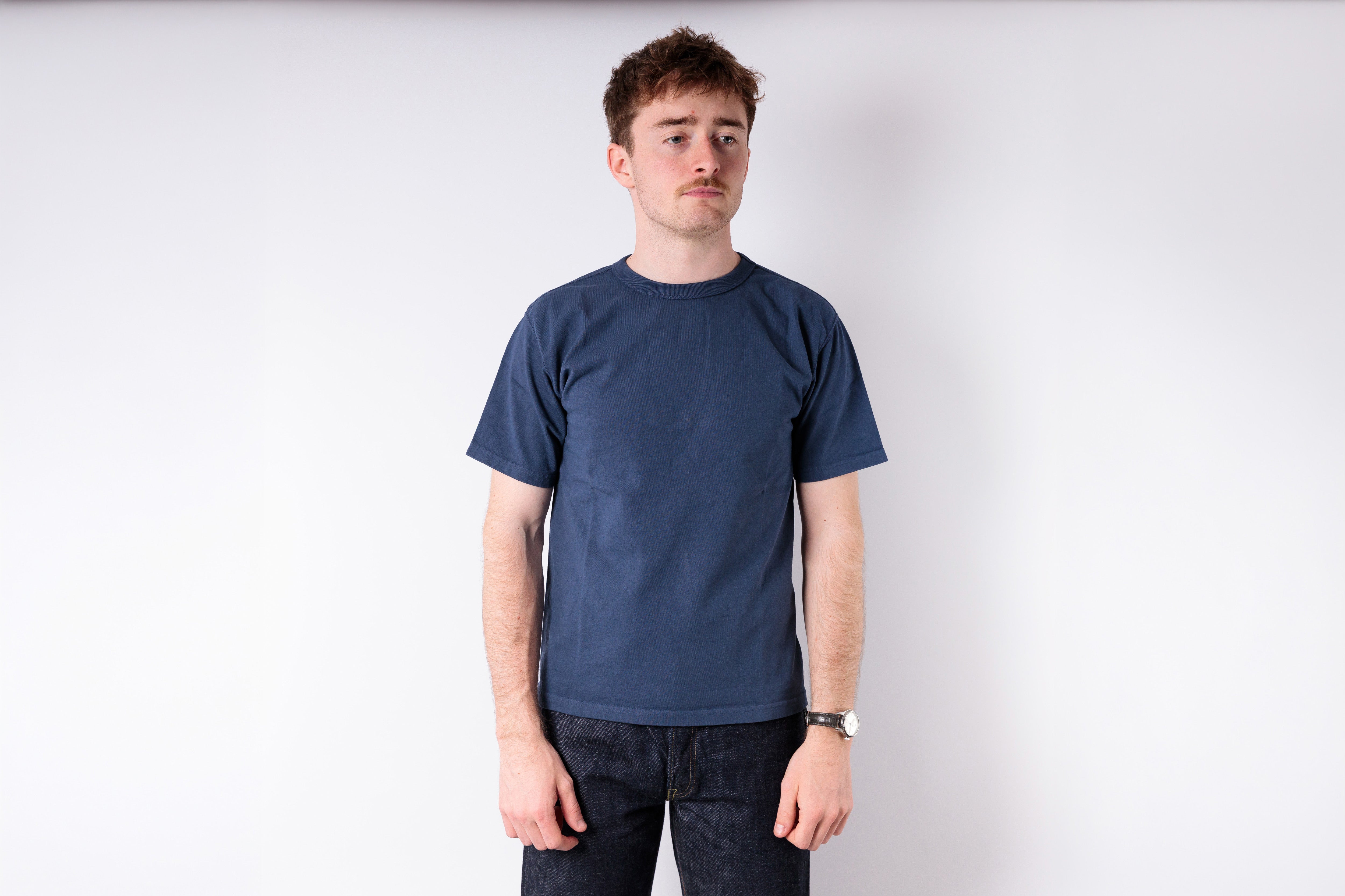 Man wearing a blue t-shirt against a white background