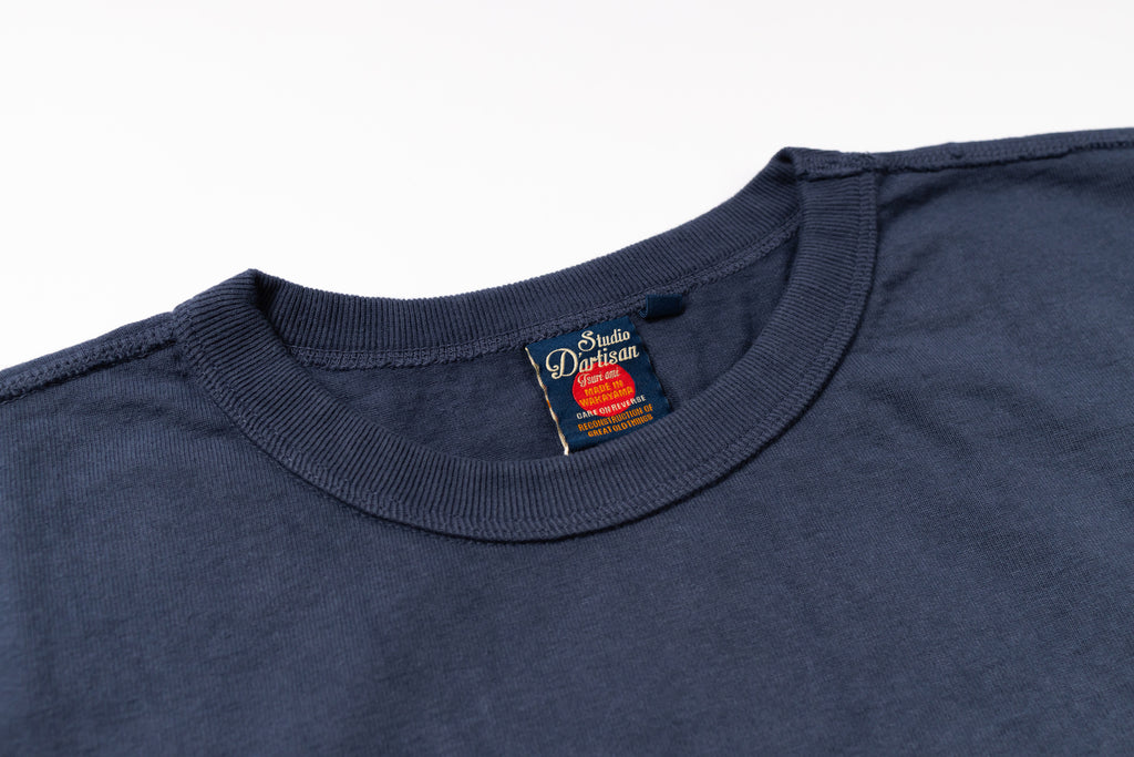Close-up of a navy blue t-shirt with a brand label on a white background