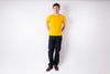 Person wearing a yellow shirt and dark pants on a white background