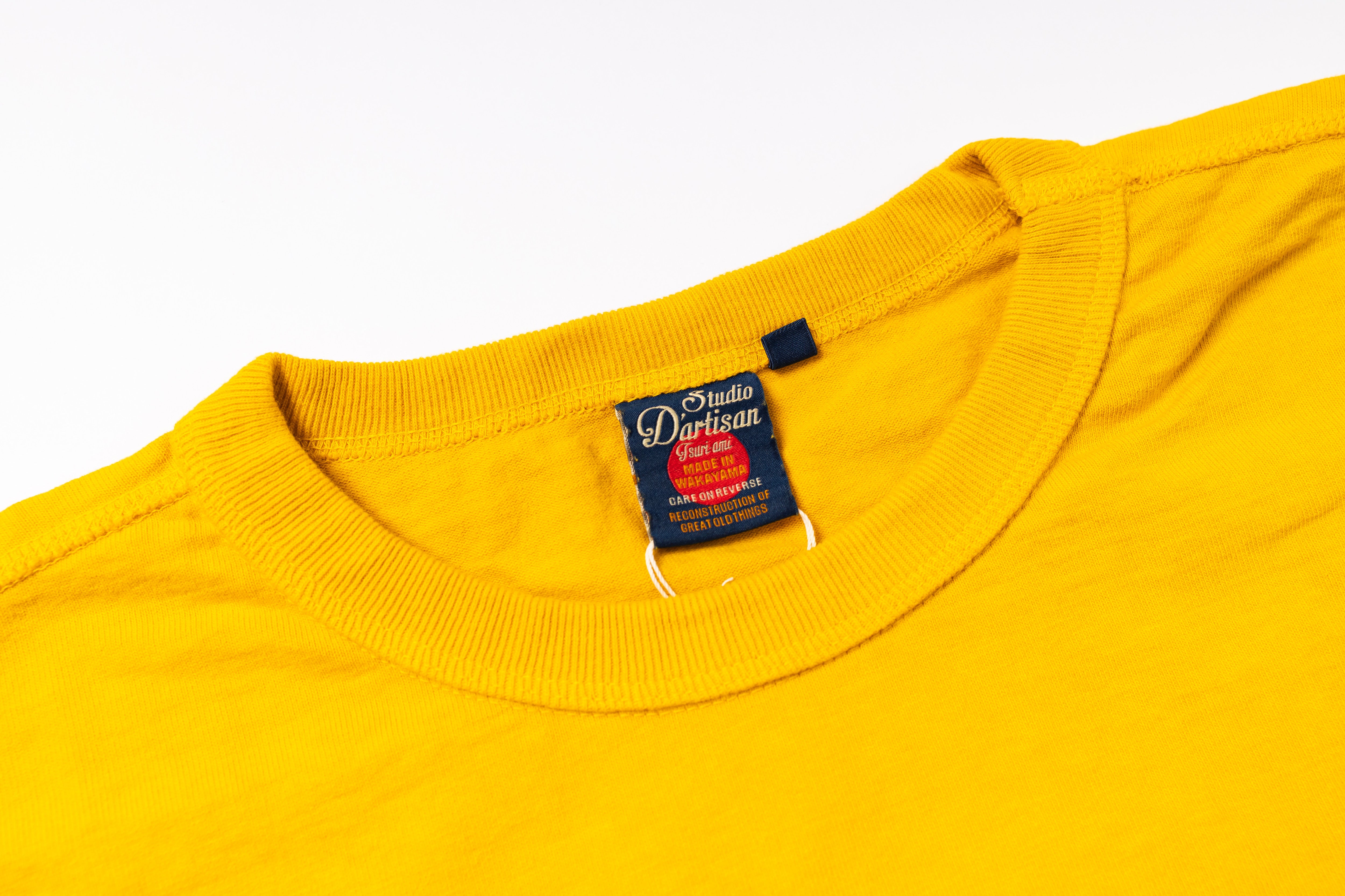 Yellow t-shirt with a brand label on a white background
