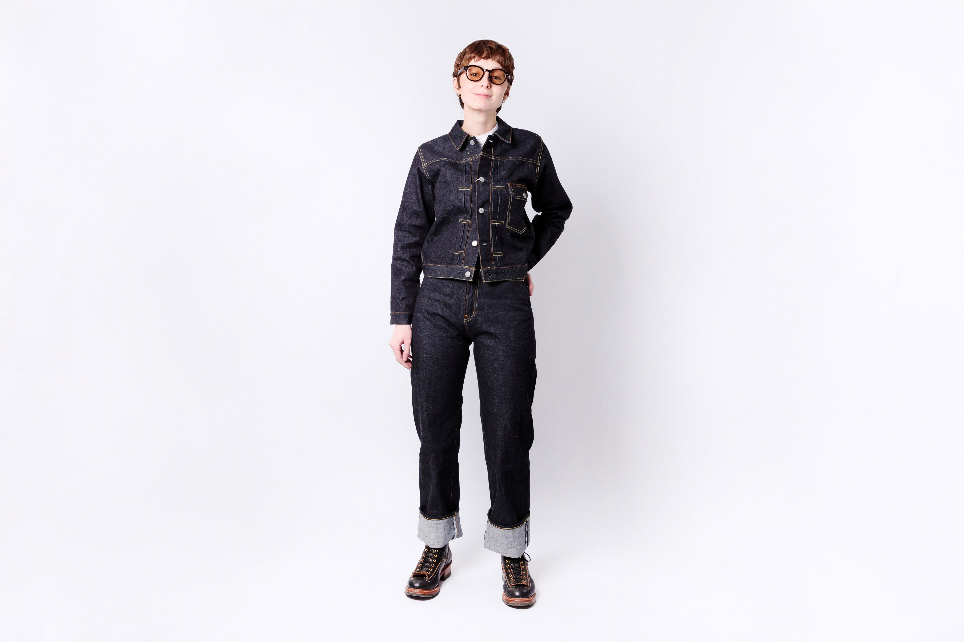 Person wearing a black denim outfit on a white background