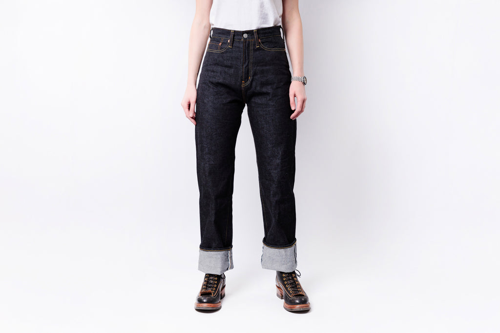 Person wearing dark blue jeans with a white background